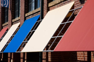Colorful fabric awnings on a brick building.
