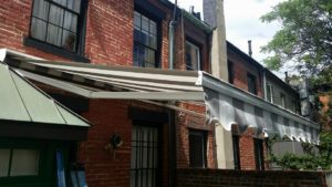 a retractable awning against brick building residential NYC