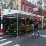 Outdoor seating area of Caffe Napoli on a city street.